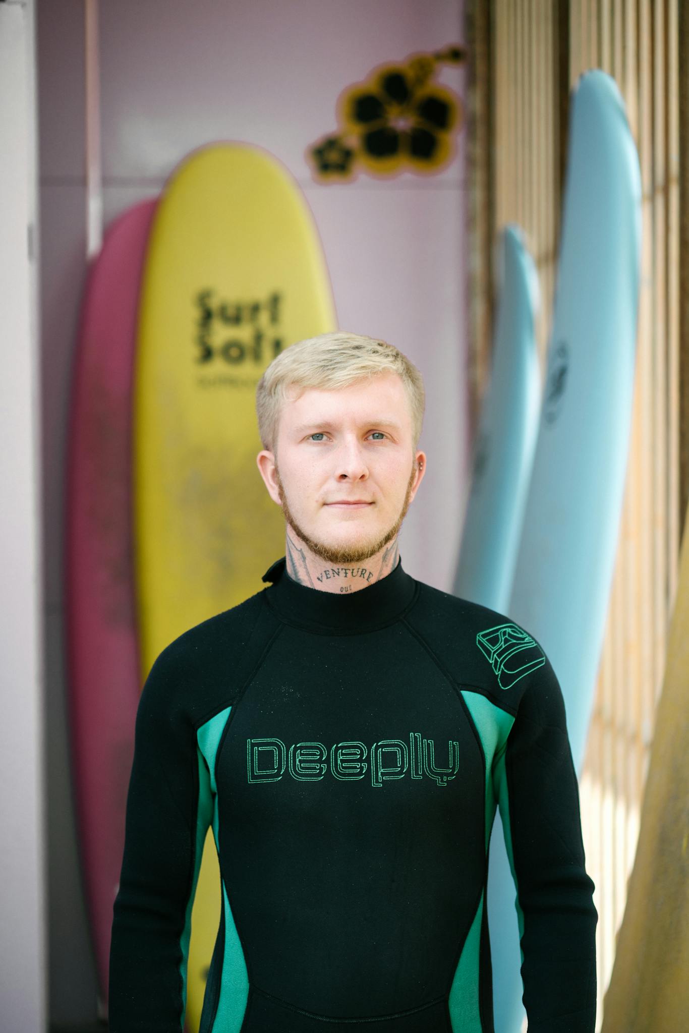 Young male surfer in wetsuit looking at camera